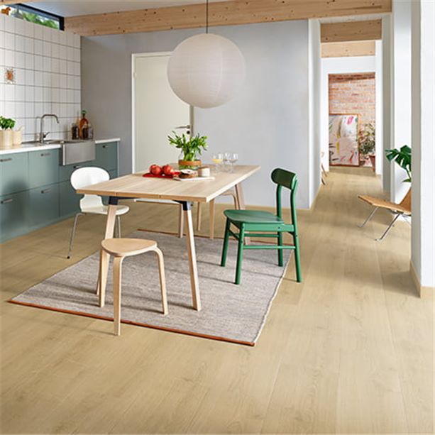 kitchen with colorful chairs at a dining table and a beige laminate floor from pergo